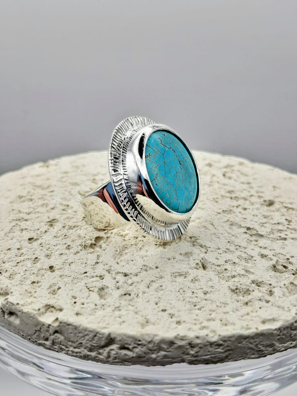 Anillo con piedra turquesa ovalada, engaste cabuchón y borde cincelado